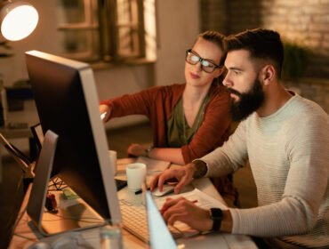 Young business colleagues using computer while working together in the office.